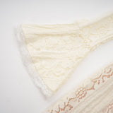 A neutral colored mini dress with floral lace pattern and flared cuffs called Emeline