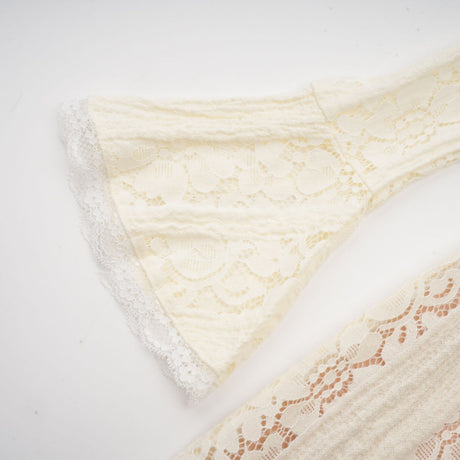A neutral colored mini dress with floral lace pattern and flared cuffs called Emeline