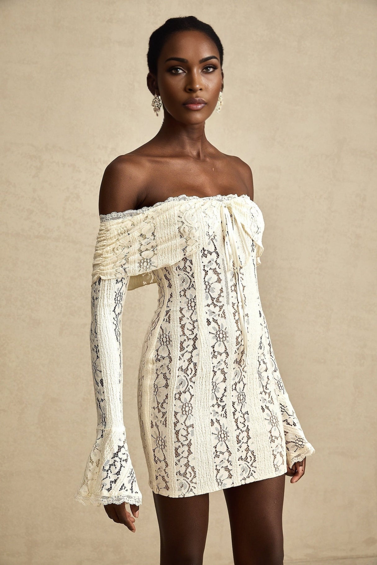 A neutral colored mini dress with floral lace pattern and flared cuffs named Émeline