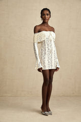 A neutral colored mini dress with floral lace pattern and flared cuffs named Émeline