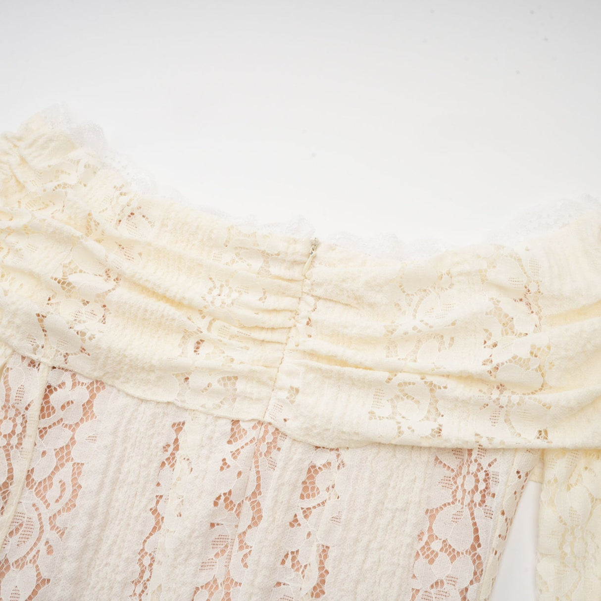 A neutral colored mini dress with floral lace pattern and flared cuffs named Émeline
