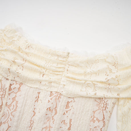 A neutral colored mini dress with floral lace pattern and flared cuffs named Émeline