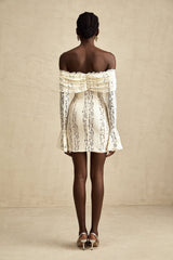 A neutral colored mini dress with floral lace pattern and flared cuffs named Émeline