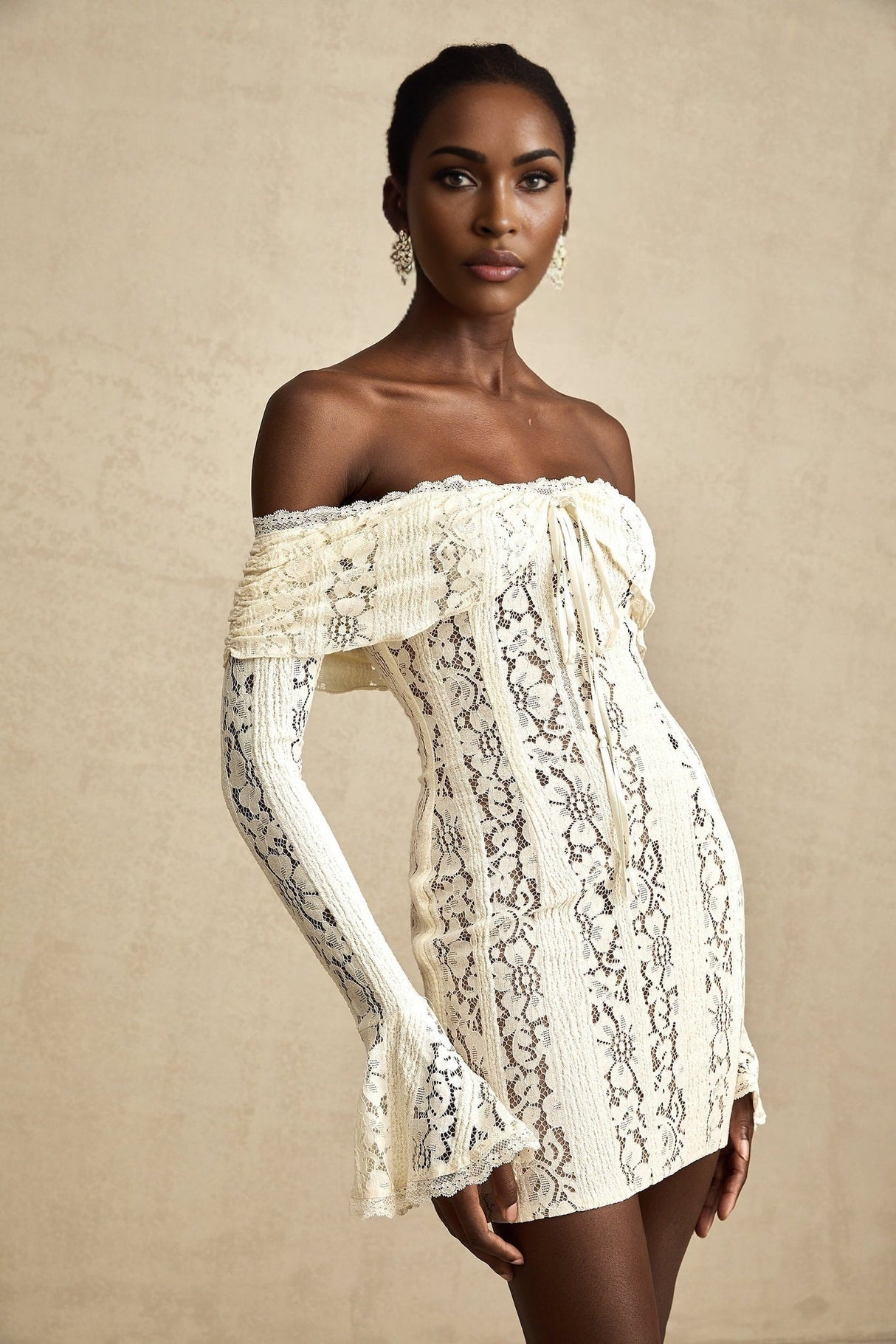 A neutral colored mini dress with floral lace pattern and flared cuffs named Émeline