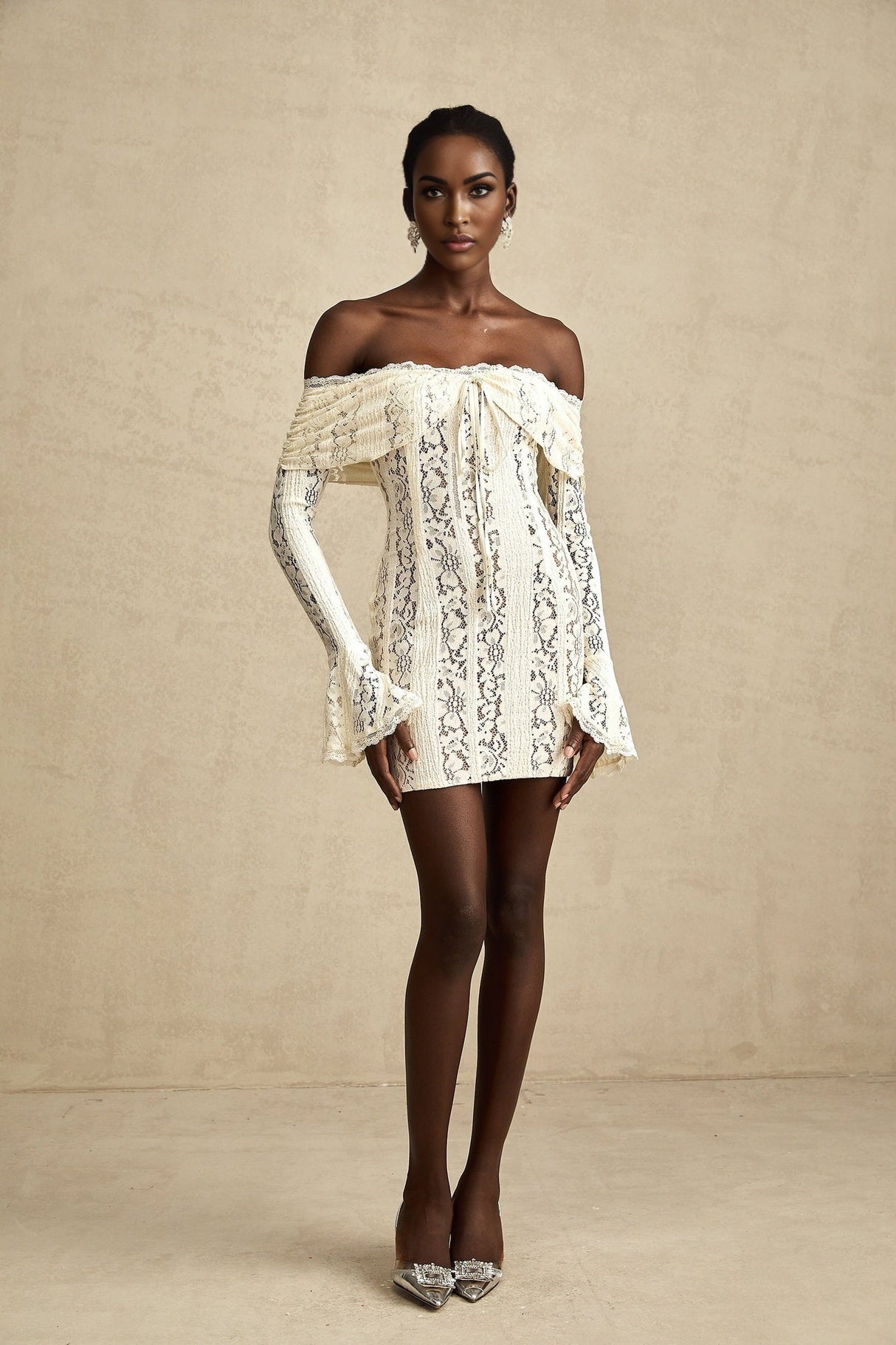 A neutral colored mini dress with floral lace pattern and flared cuffs named Émeline