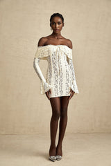 A neutral colored mini dress with floral lace pattern and flared cuffs named Émeline