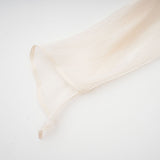 A neutral colored mini dress with full pleats and ruffles named Eugenie featuring a short hemline and feminine design