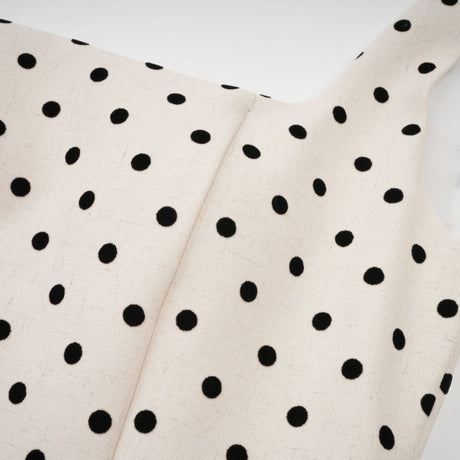 A neutral colored mini dress with polka dot pattern and puff sleeves in a short length style