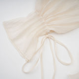 A neutral colored mini dress with tiered skirt and floral applique details called Zephyrine