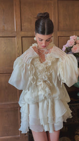 A neutral colored short tiered mini dress with floral applique details called Zephyrine