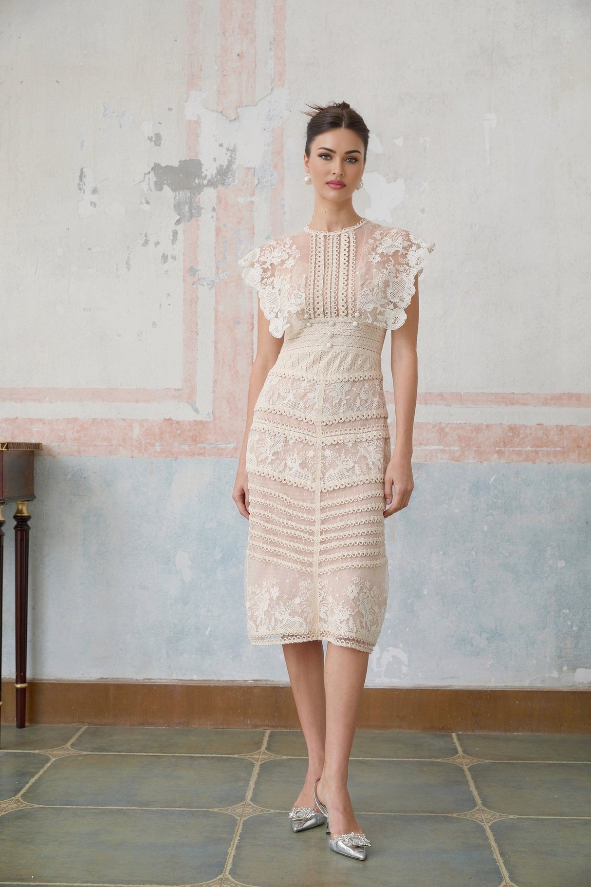 A neutralcolored midi dress with floral embroidery and lace detailing featuring delicate fleur patterns throughout the design