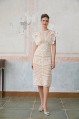 A neutralcolored midi dress with floral embroidery and lace detailing featuring delicate fleur patterns throughout the design