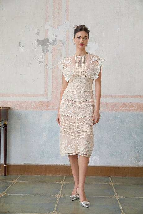 A neutralcolored midi dress with floral embroidery and lace detailing featuring delicate fleur patterns throughout the design