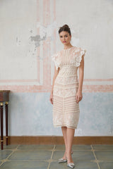 A neutralcolored midi dress with floral embroidery and lace details featuring a delicate fleur pattern