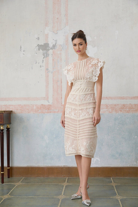 A neutralcolored midi dress with floral embroidery and lace details featuring a delicate fleur pattern