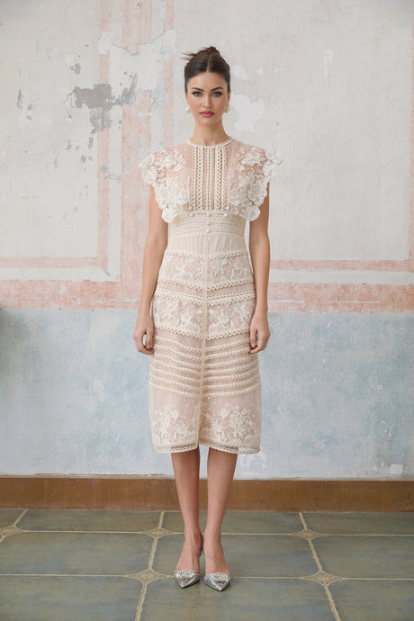 A neutralcolored midi dress with floral embroidery and lace details featuring delicate fleur patterns throughout the design