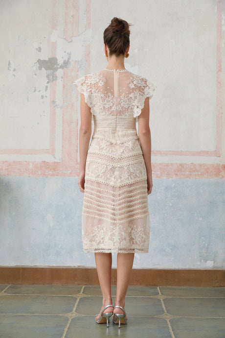 A neutralcolored midi dress with floral embroidery and lace details named Fleur