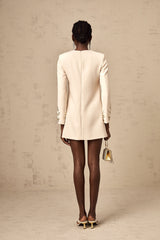 A neutralcolored mini dress with long sleeves adorned with crystal embellishments called Melissa