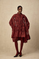 A pair of red tights with floral lace pattern and cut out details on display