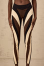 A pair of womens leggings featuring a spiral color block design with multiple panels in different colors