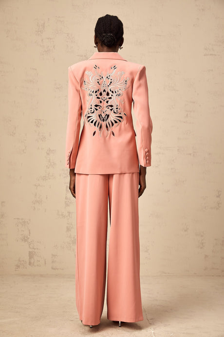 A pink blazer and trouser set with embroidery details and cutout designs The blazer features a tailored silhouette with decorative cutouts while the matching trousers have a sleek fit Both pieces are adorned with intricate pink embroidery creating an elegant and coordinated outfit