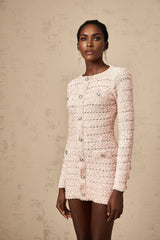 A pink fitted knit mini dress on a mannequin or model showcasing its formfitting silhouette and short length