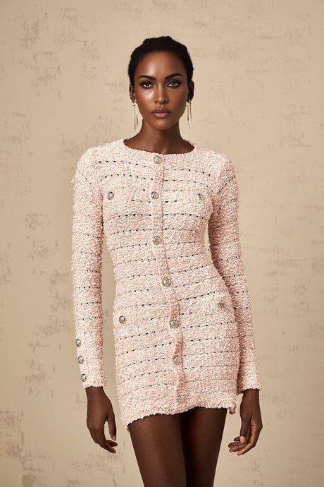 A pink fitted knit mini dress on a mannequin or model showcasing its formfitting silhouette and short length