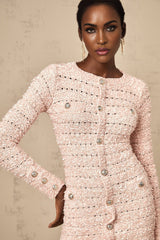 A pink fitted knit mini dress on a model showing a snug silhouette and short length