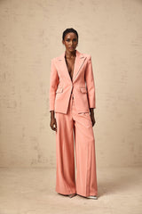 A pink matching set featuring a blazer and trousers with embroidery details and cutout designs The blazer has long sleeves and the trousers are full length Both pieces have a tailored fit and coordinating embroidery patterns