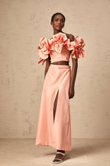 A pink matching set featuring a top and skirt with floral applique detailing named Yvette