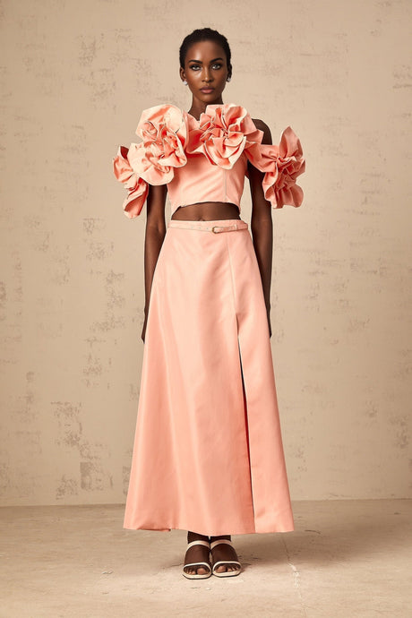 A pink matching set featuring a top and skirt with floral applique details on both pieces