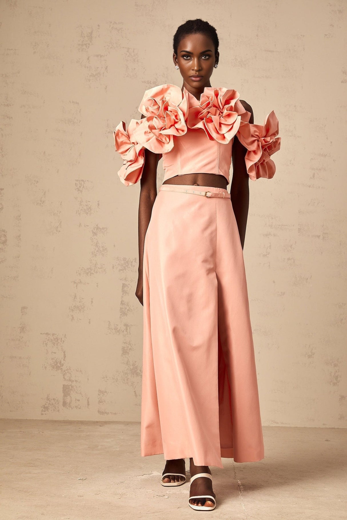 A pink matching set featuring a top and skirt with floral applique details