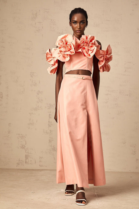 A pink matching set featuring a top and skirt with floral applique details
