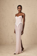 A pink maxi dress with rhinestone embellishments and a semi sheer design featuring a long flowing silhouette