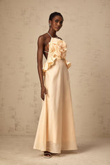 A pink maxi dress with ruffled 3d petal details along the body and skirt creating a textured floral effect throughout the garment