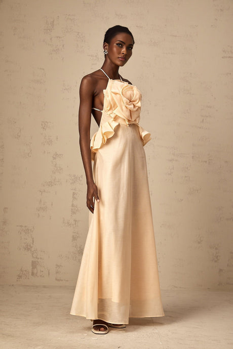 A pink maxi dress with ruffled 3d petal details along the body and skirt creating a textured floral effect throughout the garment