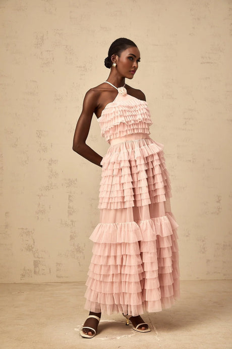 A pink maxi dress with ruffled tiered tulle skirt and floral petal brooch detail