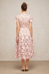 A pink midi dress made of delicate guipure lace featuring intricate floral patterns and a feminine silhouette