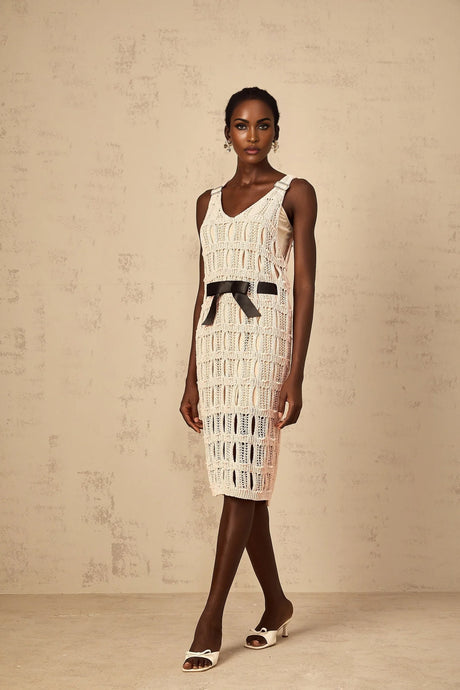A pink midi dress with a crochet knit pattern featuring a decorative bowknot detail