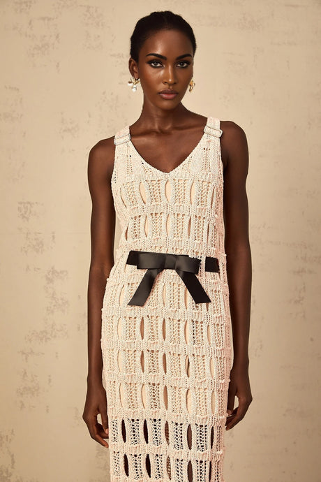 A pink midi dress with a crochet knit pattern featuring a decorative bowknot detail