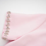 A pink midi dress with a large bow detail adorned with crystal accents inspired by the Cassiopeia constellation