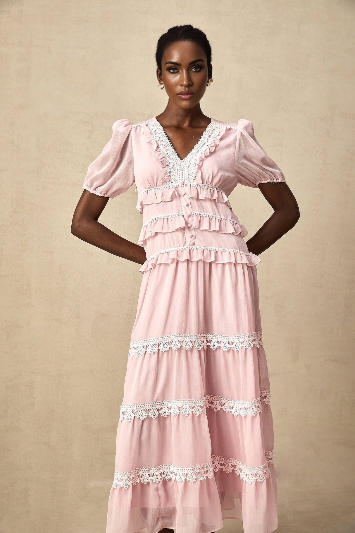 A pink midi dress with a ruffled tiered skirt and Amelie style design