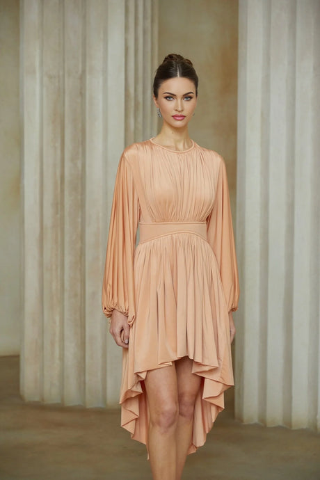 A pink midi dress with asymmetrical design and pleated details featuring a sleeveless style and flowy silhouette