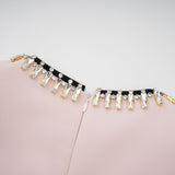 A pink midi dress with crystal embellishments and colorblocked design featuring the name Anais