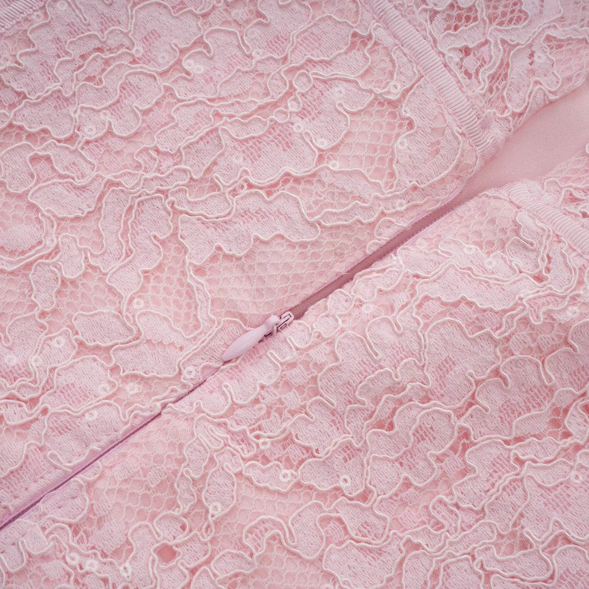 A pink midi dress with floral embroidery and lace details featuring embellishments and a feminine silhouette