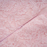 A pink midi dress with floral embroidery and lace details featuring embellishments and a feminine silhouette