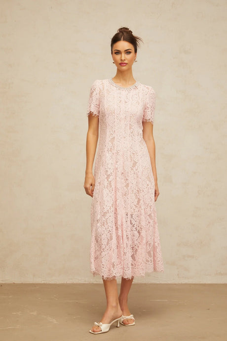 A pink midi dress with floral lace pattern and embellishments on a mannequin or model against a plain background