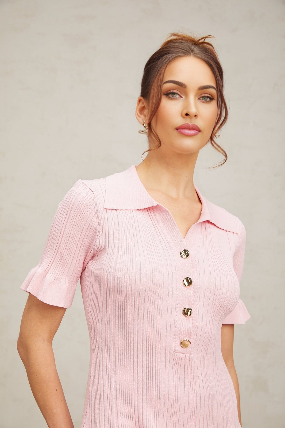 A pink mini dress with a flared skirt and fine knit fabric featuring long sleeves and a fitted bodice