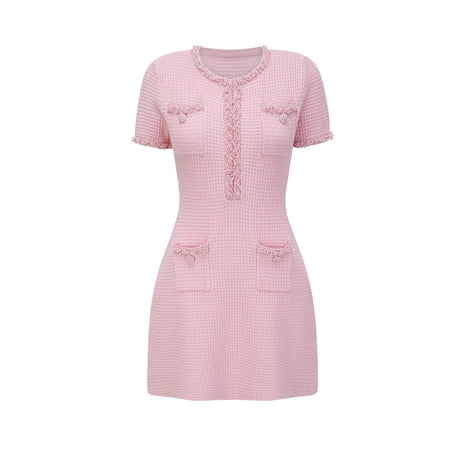 A pink mini dress with a knit fabric adorned with beaded embellishments featuring a feminine and elegant design