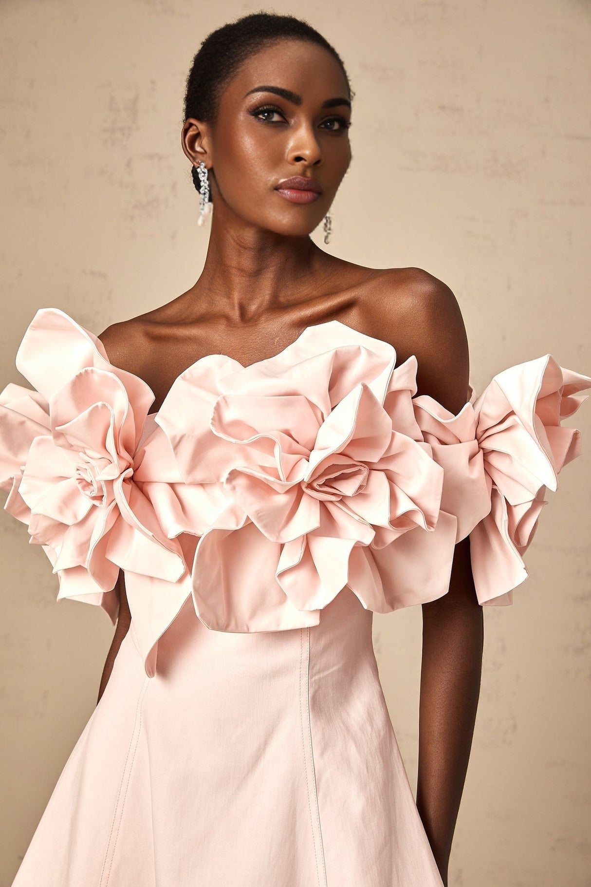 A pink mini dress with an offshoulder neckline featuring threedimensional floral petal details on the bodice and named Juliette